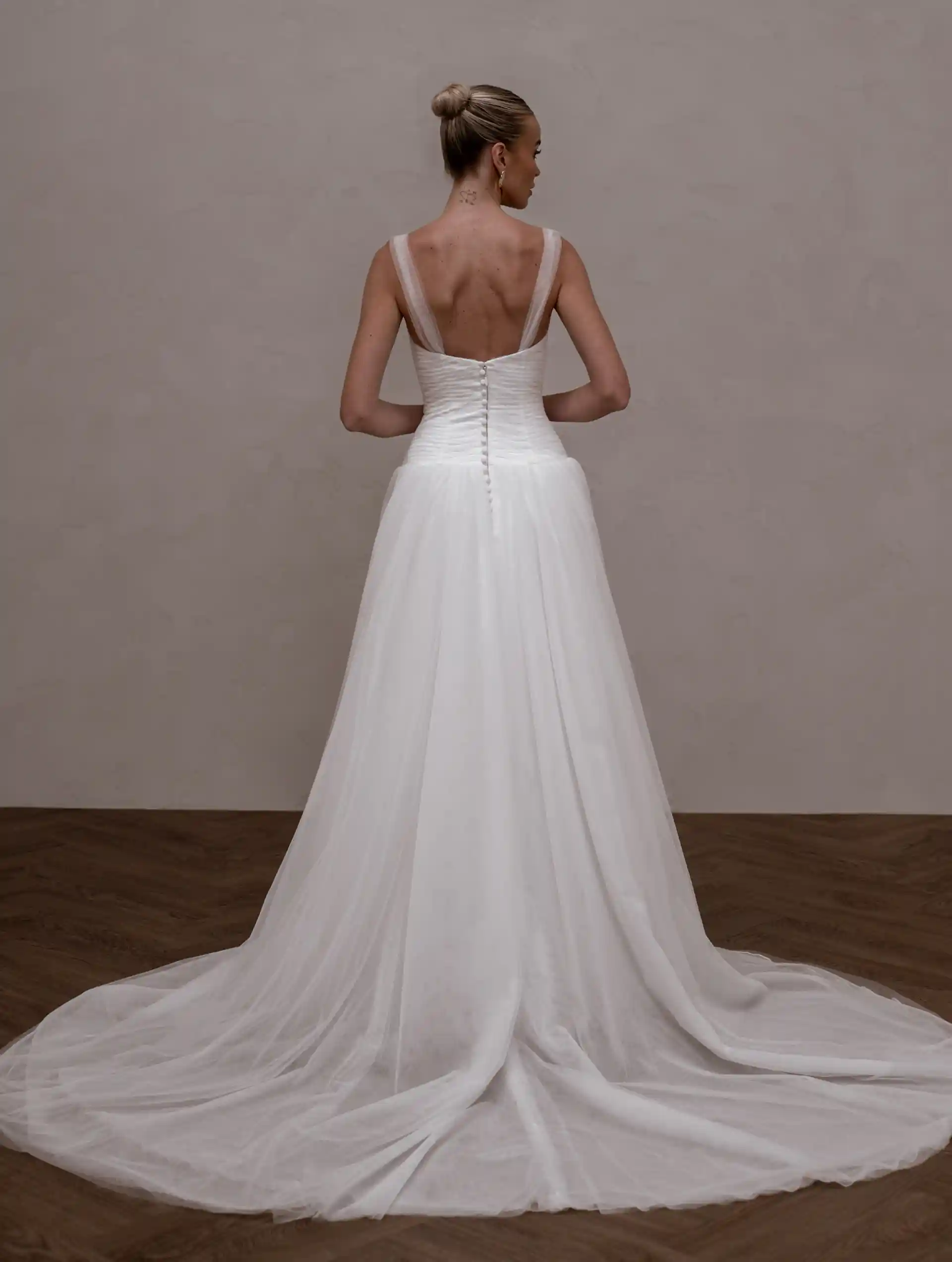 Model wearing Aire by Made With Love bridal gowns full back view
